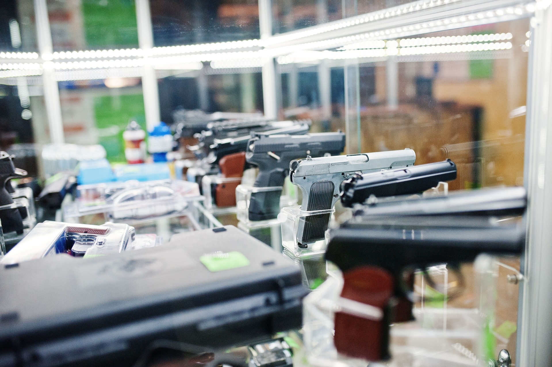 Different guns and revolvers on shelves store weapons on shop center.